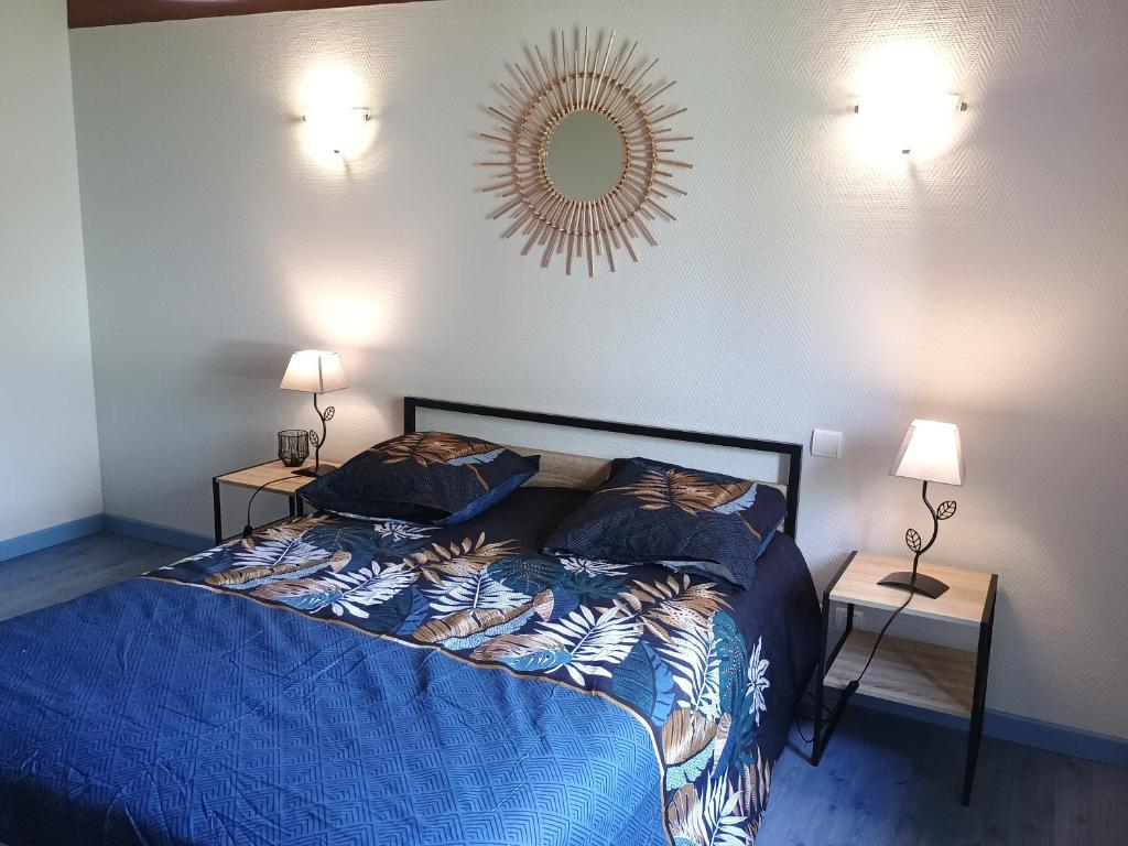 een slaapkamer met een bed en een spiegel aan de muur bij Gîte de benque in Benqué