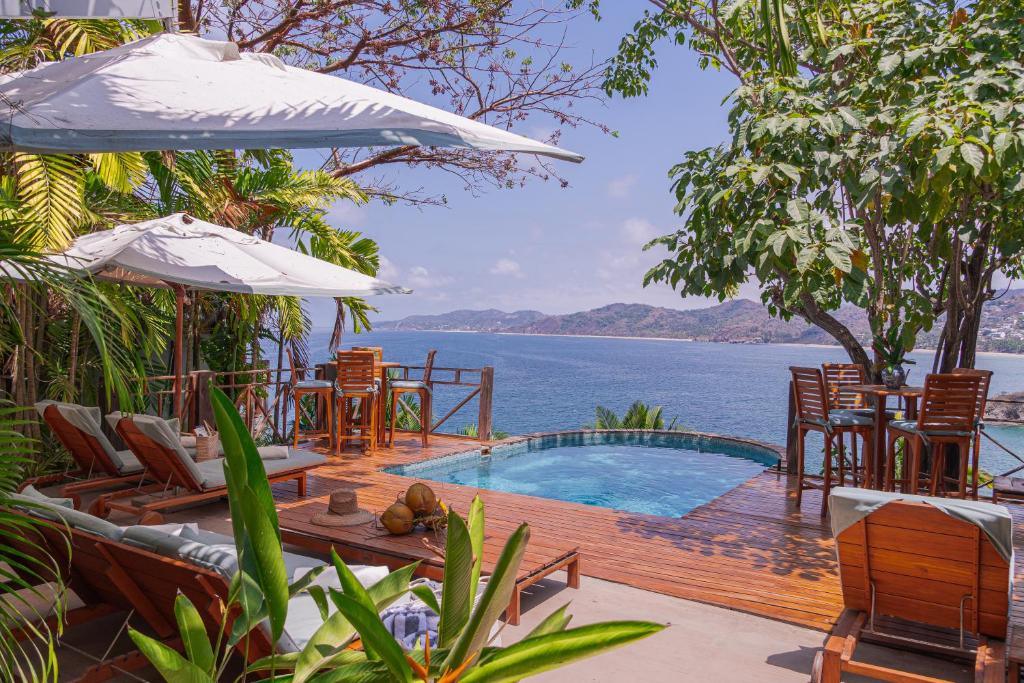 a resort with a pool and a view of the water at Hotel Boutique Siete Lunas in Sayulita