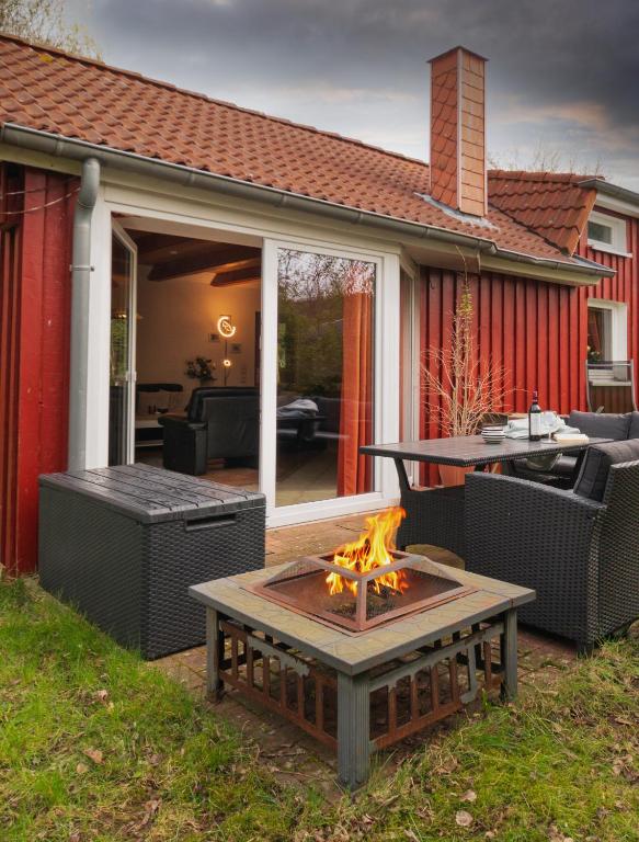 a patio with a fire pit in the yard at Schwedenstern - Familienurlaub an der Ostsee in Kochendorf