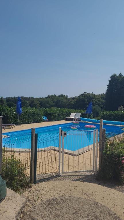 a fence in front of a swimming pool at La Grange aux coccinelles in Saint-Martin-des-Fontaines