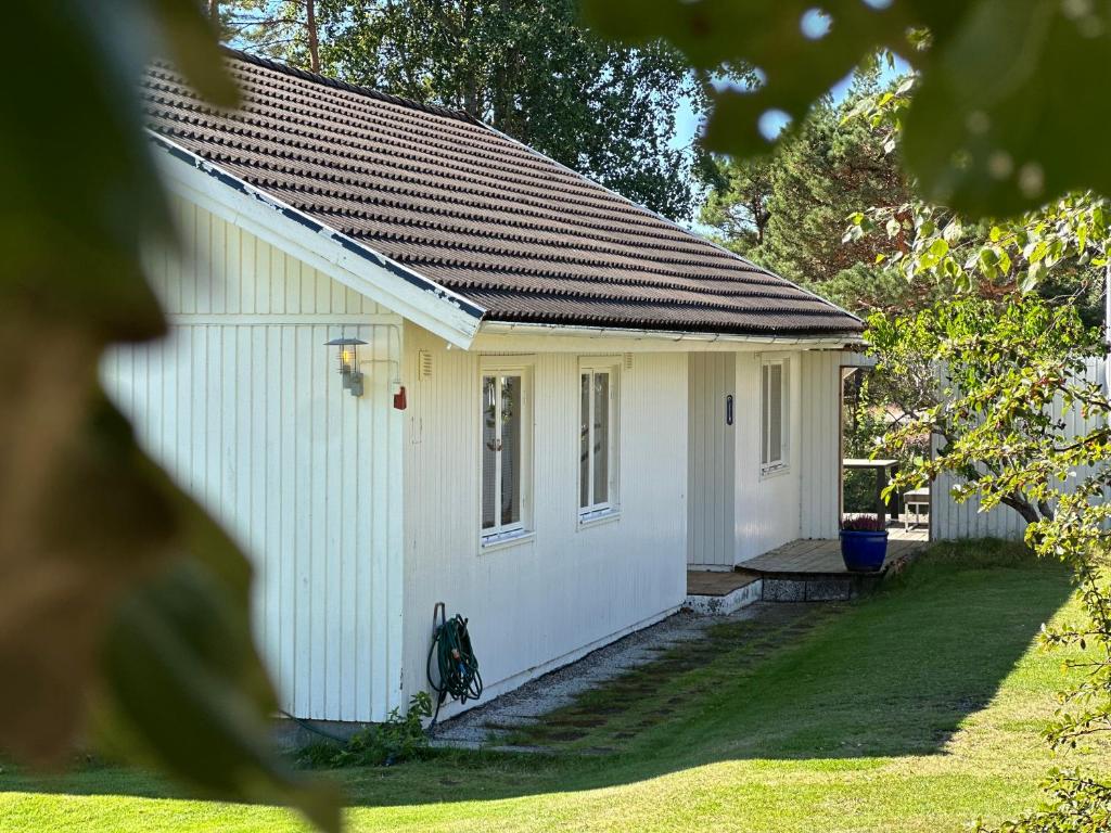 a small white building with a grass yard at Strömstad/Stromstad close to the sea in Strömstad