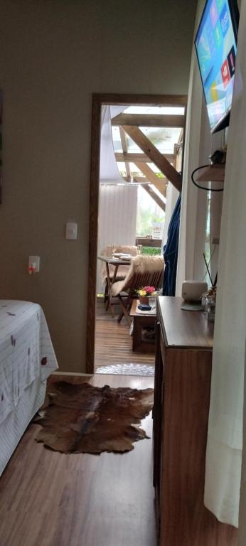 a room with a living room with a table and a television at Chalé Hidro Jurerê in Florianópolis