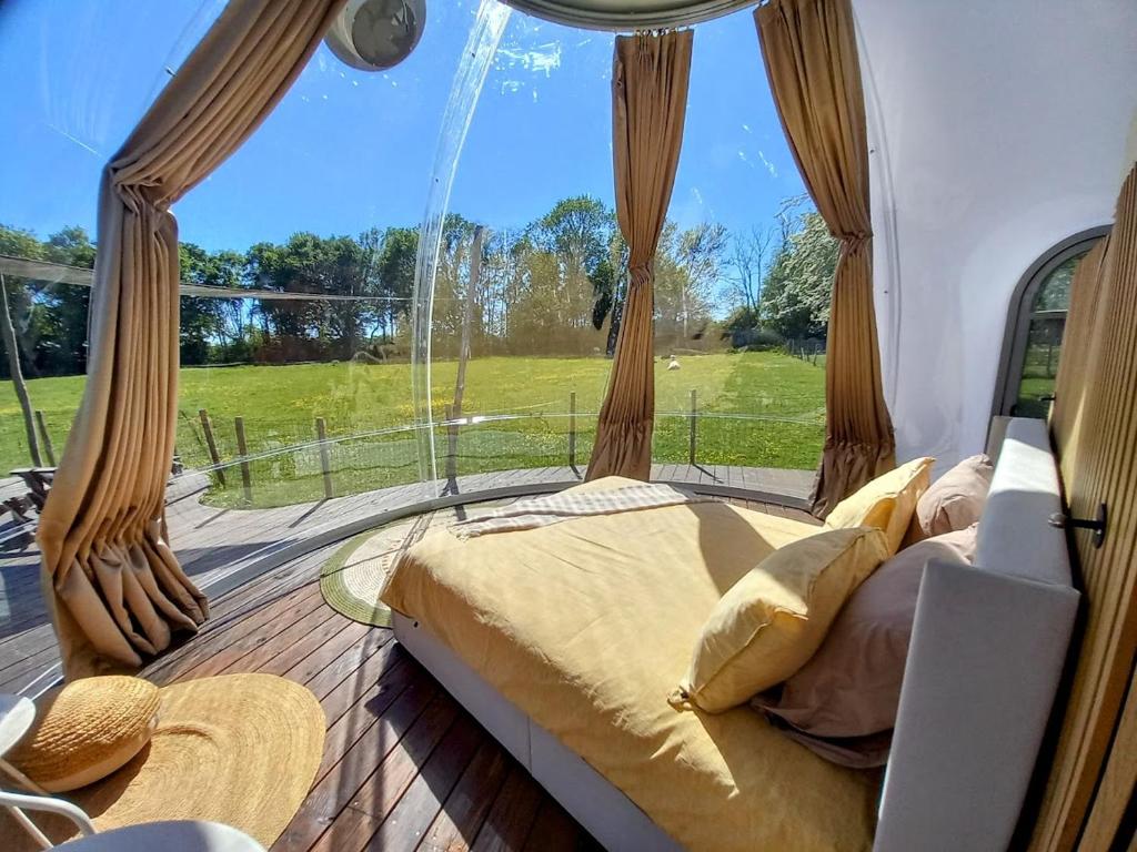 a bedroom with a bed in front of a window at La Bulle des alpagas in Herry