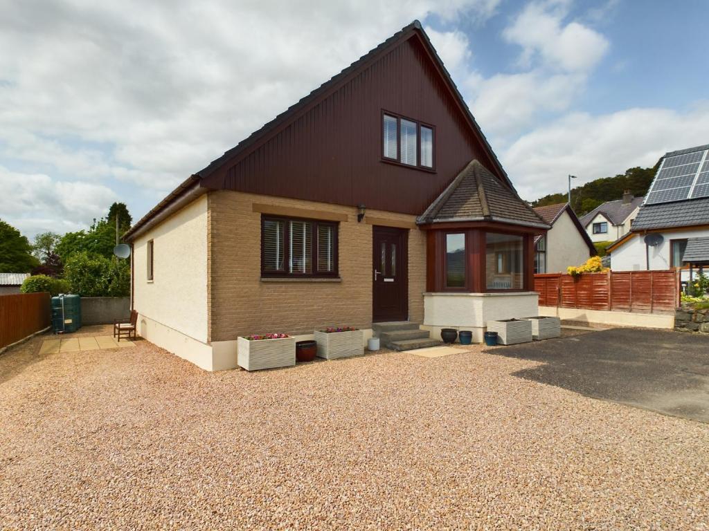 a house with a gravel driveway in front of it at Kildonan House Bed and Breakfast in Corpach