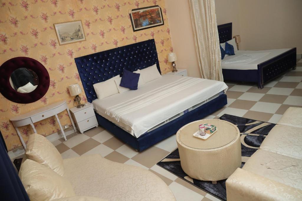 a bedroom with two beds and a couch at Sehrai Royal Villa in Multan