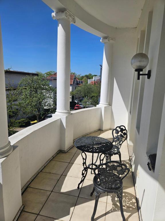 two chairs and a table on a balcony at Villa Augusta am Kurpark in Bad Salzuflen