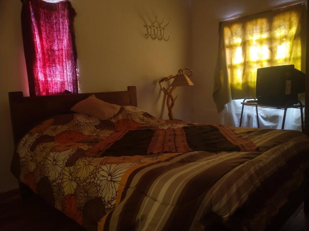 a bedroom with a bed with a blanket on it at La Ollita in Humahuaca