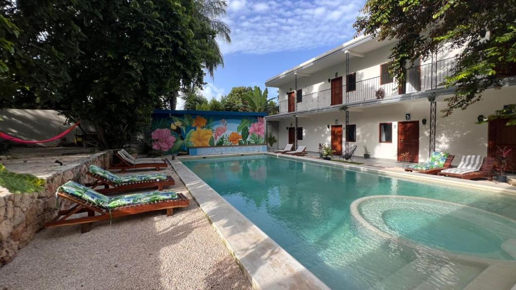 a swimming pool with two lounge chairs and a house at Casa Mexico Lindo - Boutique Hostel in Bacalar