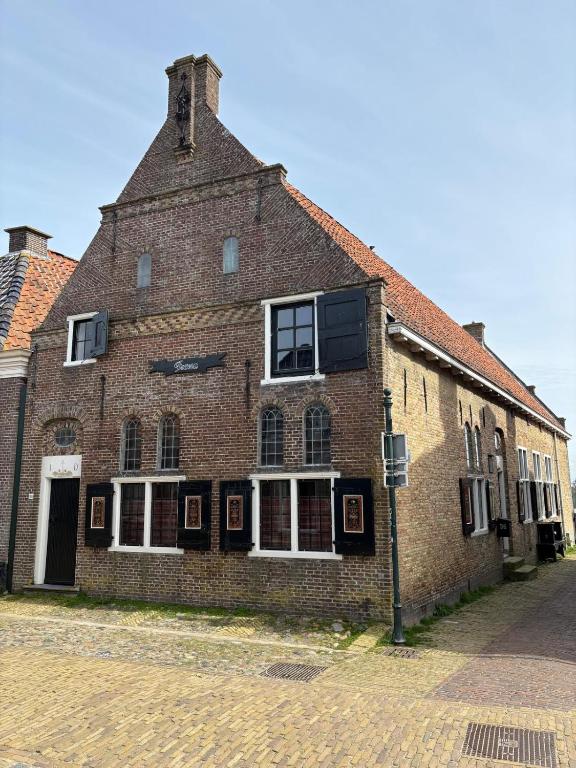 an old brick building on the side of a street at Irene 2 in Hindeloopen