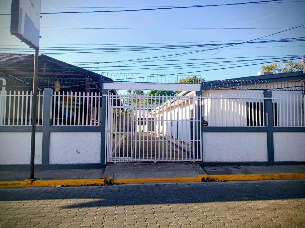 a blue and white fence next to a street at Volcano Hostal in Rivas