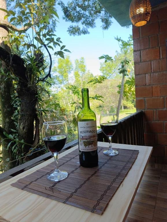 a bottle of wine and two glasses on a table at Bosque da Lua - Suite with 2 bathrooms - Up to 5 guests in Itupeva
