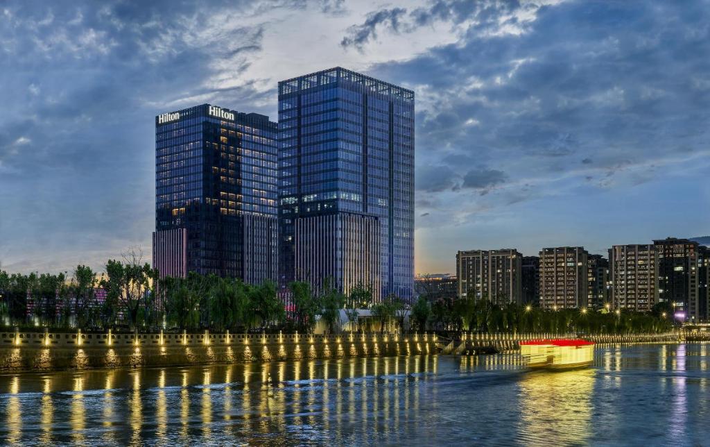 a city skyline with tall buildings and a river at Hilton Yancheng in Yancheng