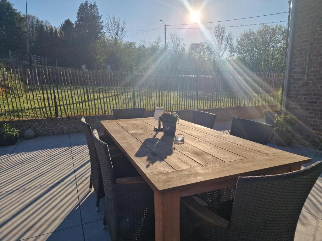 a wooden table with chairs on a patio at Gîte au cœur de la famenne in Houyet