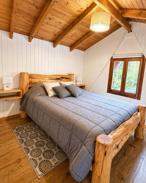 a bedroom with a large bed in a room with wooden ceilings at Cabañas Chucao 2 in San Martín de los Andes