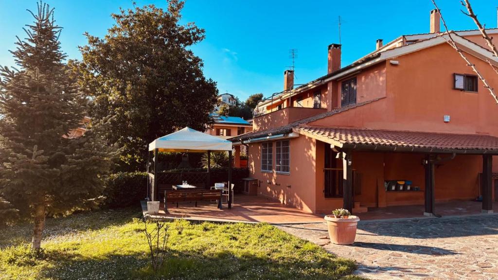 a house with a table and a white umbrella at A casa nostra in Formello