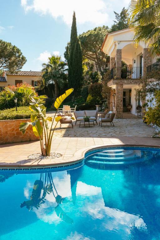 a swimming pool in front of a house at Villa Maravilla in Lloret de Mar