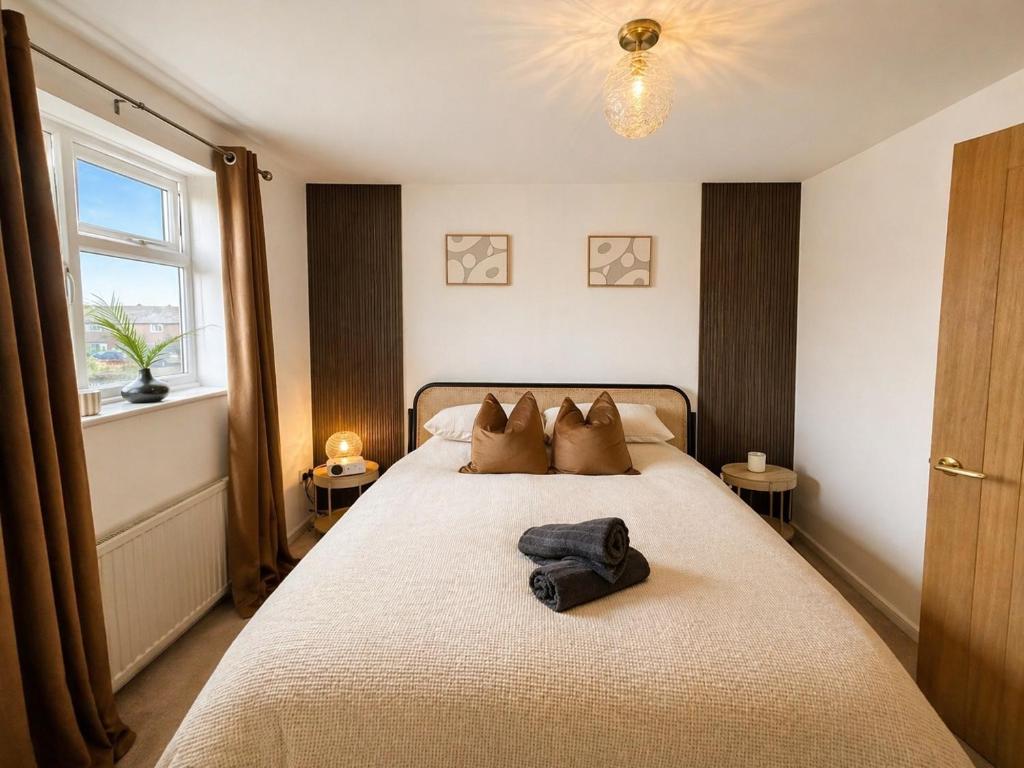 a bedroom with a bed with a robe on it at Golden Sands Escape Weymouth Entire House in Wyke Regis