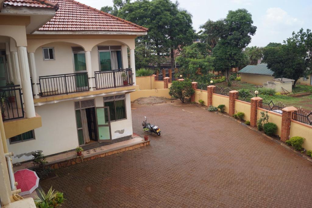 a house with a motorcycle parked in a driveway at Durban Motel Najjanankumbi Kampala in Kampala