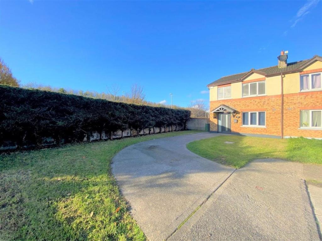 a house with a driveway in front of a hedge at Dublin Cosy Home in Dublin