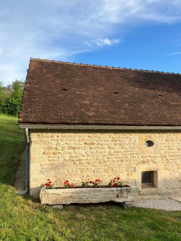 a brick building with flowers on the side of it at Le Verger de la Tannerie in Chesley