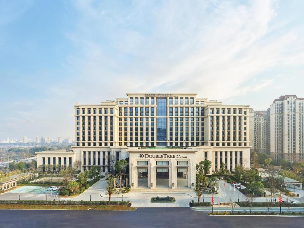 a large white building in front of a city at Doubletree By Hilton Quzhou in Quzhou