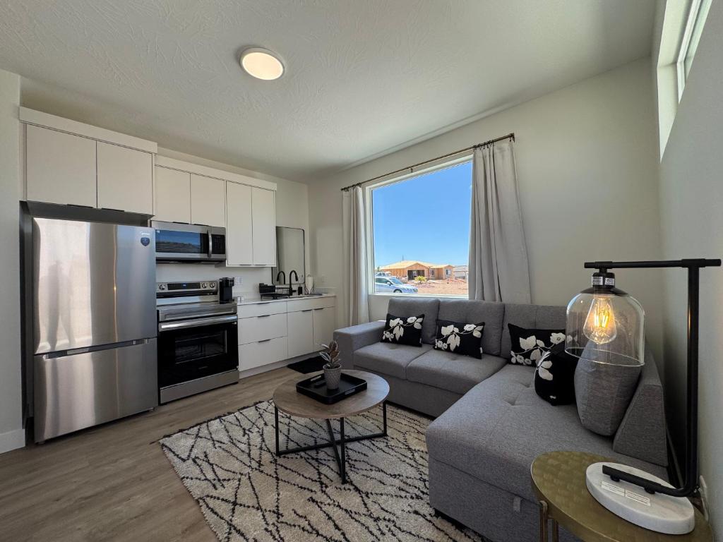 a living room with a gray couch and a kitchen at New Casita by Zion National Park and Saint George in Hurricane