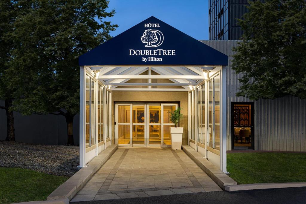 a building with a blue awning and a door at Doubletree By Hilton Pointe Claire Montreal Airport West in Pointe-Claire