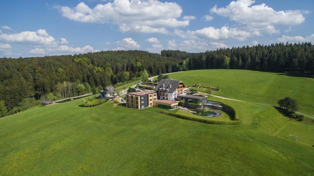 widok z góry na duży dom na zielonym polu w obiekcie Hotel Schwarz Alm Zwettl w mieście Zwettl-Niederösterreich
