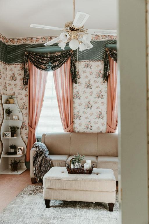 a living room with a couch and a ceiling fan at Strassner Suites - Imy Suite in Hermann