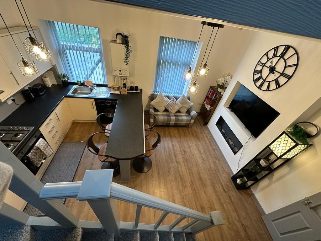 an overhead view of a living room and kitchen with a clock at Snuggle Inn Burnley in Burnley