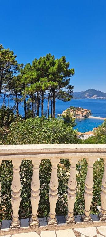 a white railing with a view of the ocean at Apartmani Fico II in Sveti Stefan