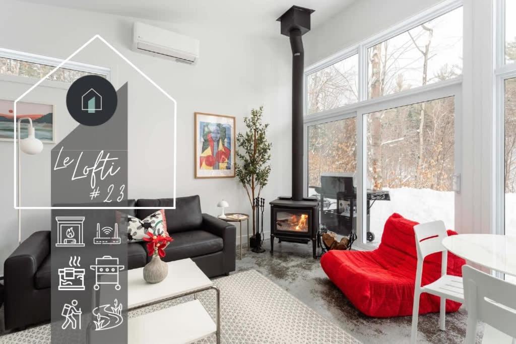 a living room with a couch and a fireplace at The Lofti in Sainte Béatrix