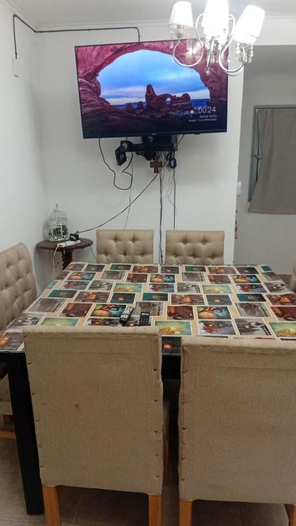 a dining room table with chairs and a tv on the wall at Duplex parque in Santiago del Estero