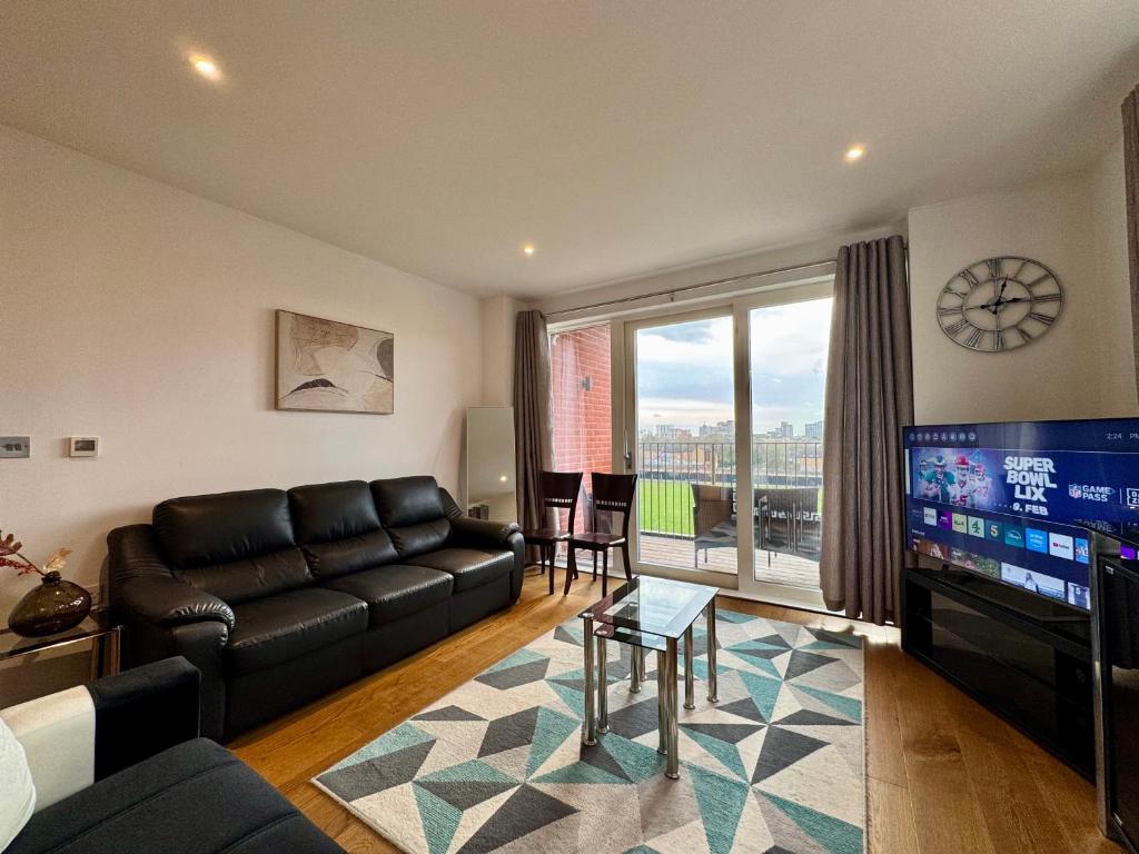 a living room with a couch and a flat screen tv at Stunning 2Bedrooms, 2Baths, Balcony, Parking in Colindale