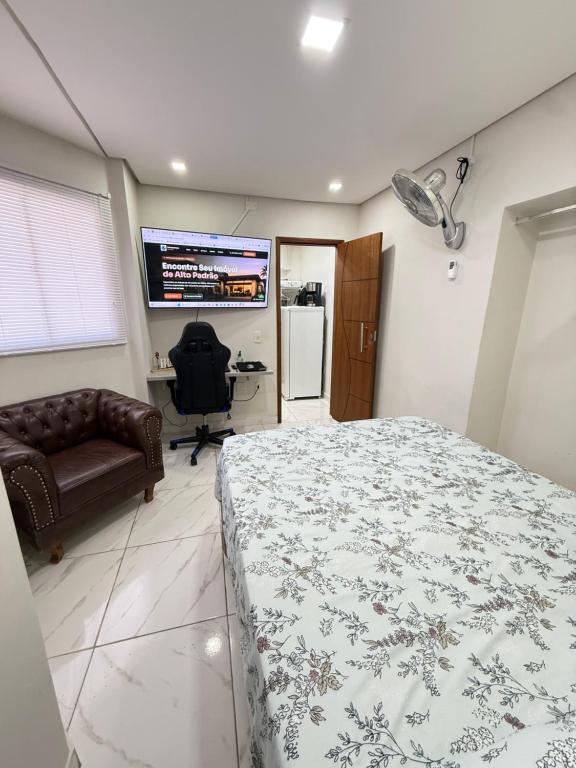 a bedroom with a bed and a couch and a television at Centro de Vitoria in Vitória