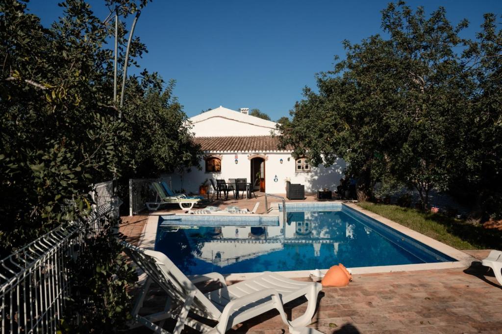 a swimming pool with two chairs and a house at Casa Da Maria - Villa with Private Pool and Barbecue in Fonte do Bispo