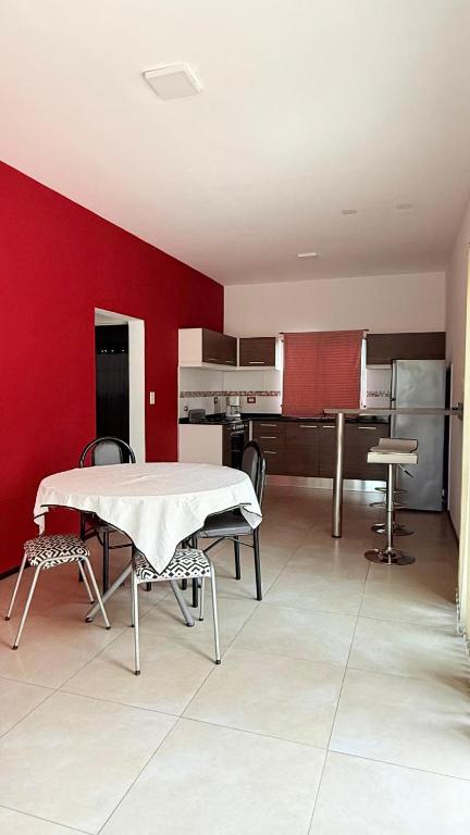 a living room with a table and a red wall at Casa en planta alta in Rosario