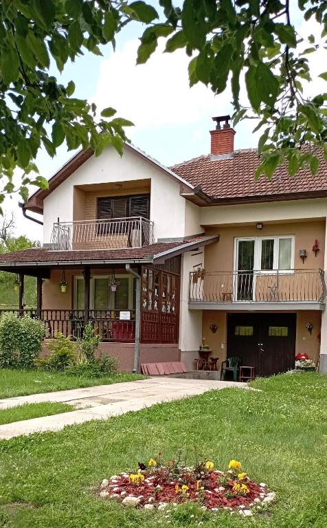 a house with a balcony and a yard at Kuca za odmor Zicanka in Kraljevo