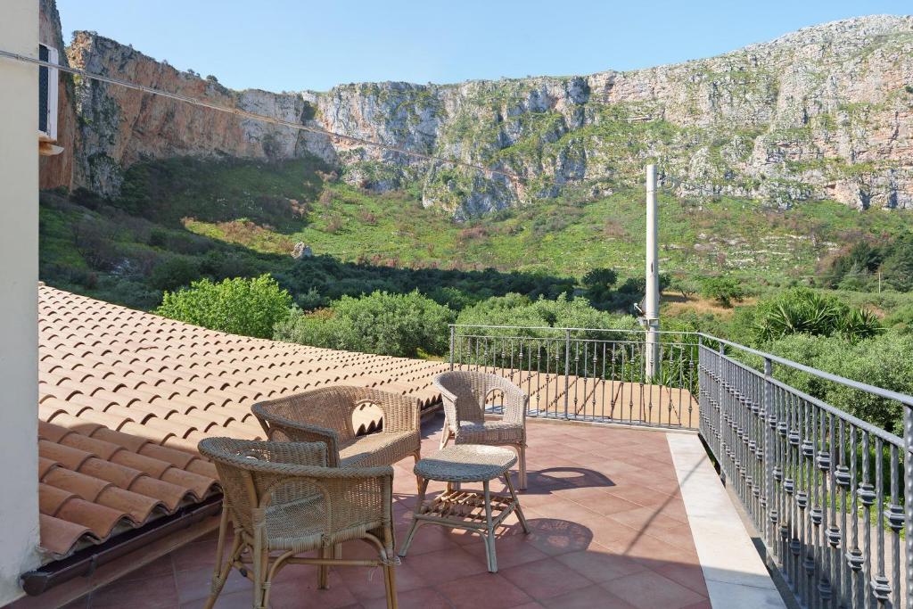 a balcony with chairs and tables and a mountain at Villa Gheta At The Monte Cofano in Custonaci