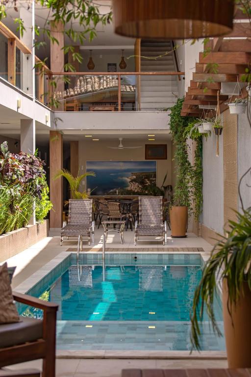 a swimming pool with chairs and a table on a building at Terra Bella Pousada in Morro de São Paulo