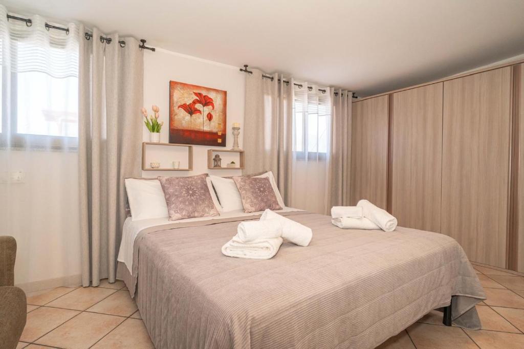 a bedroom with a large bed with towels on it at Hedoné apartment in Schisò