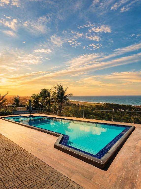 a swimming pool with a view of the ocean at Pousada Hope Club in Beberibe
