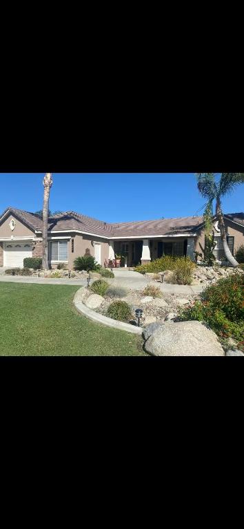 a large house with a palm tree in a yard at The Casita at Riverwalk in Bakersfield
