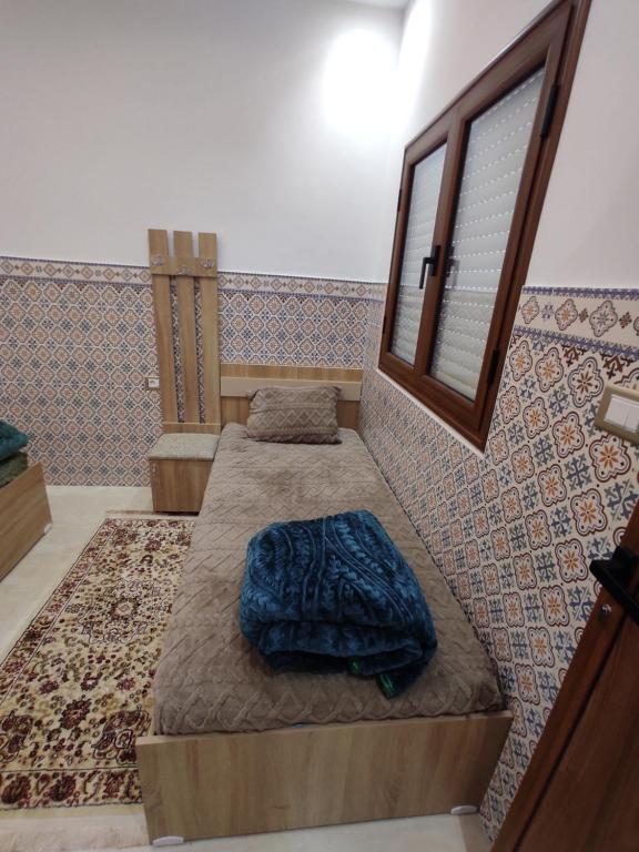 a room with two beds and a window at اقامة يوسف اللكراء in Gabès