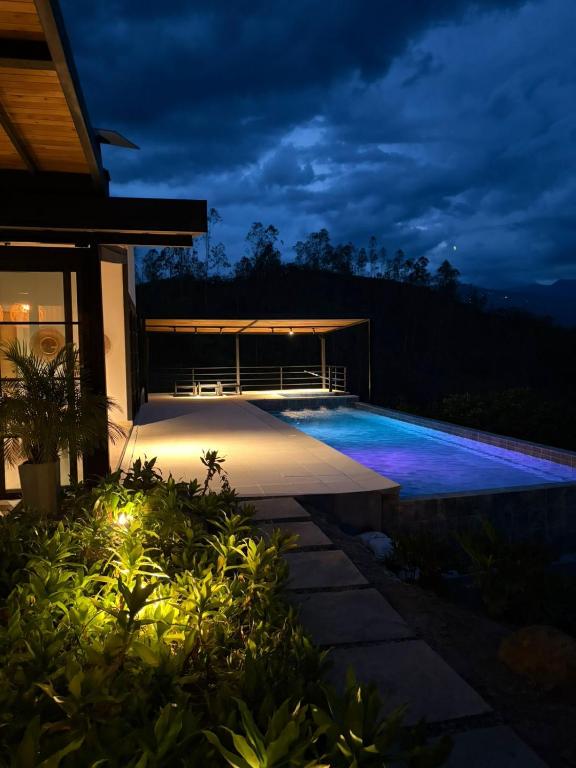 a swimming pool in a backyard at night at CASALIA Sopetran in Sopetrán