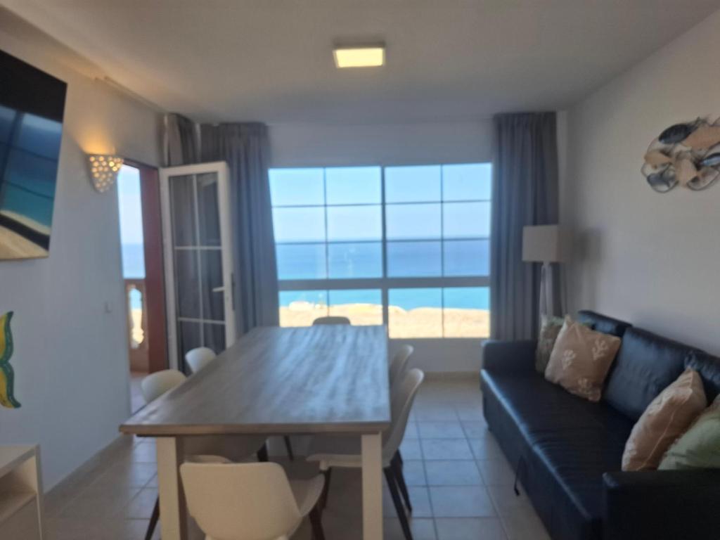 a living room with a table and a couch at Paraíso Jandia beach in Costa Calma