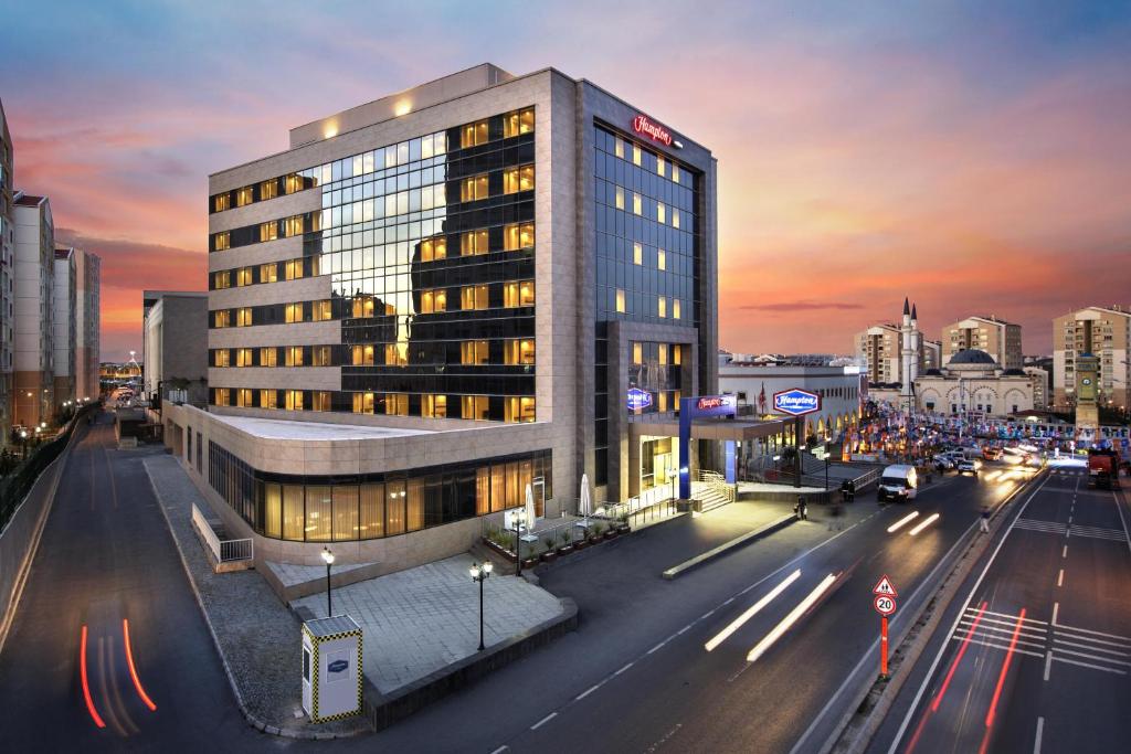 a building on a city street with a busy street at Hampton by Hilton Istanbul Kayasehir in Istanbul