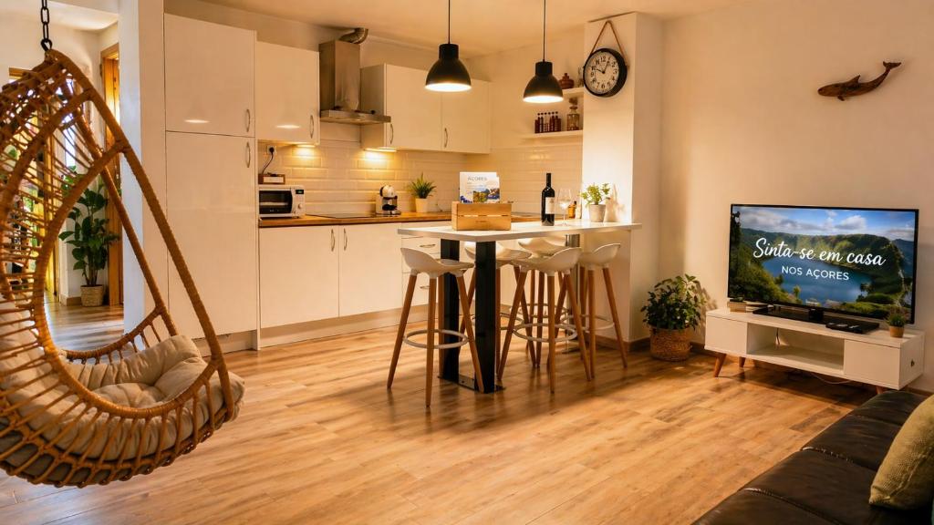 a living room with a table and a kitchen at Casa da Corisca in Vila Franca do Campo