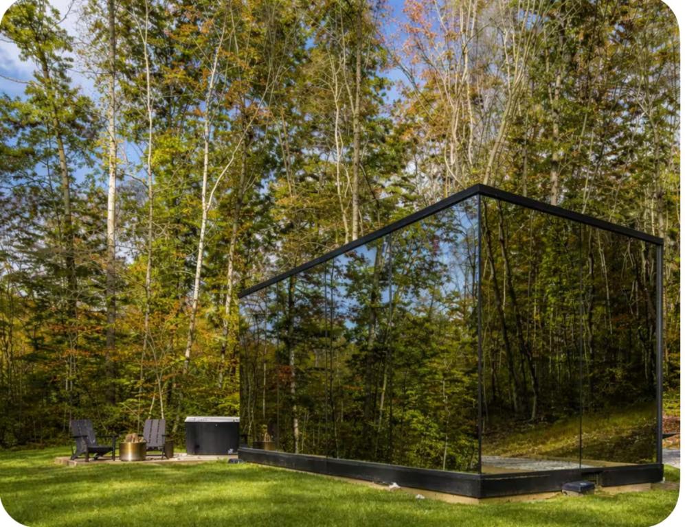 a glass house in the middle of a yard at The Illusion Hideaway in New Plymouth
