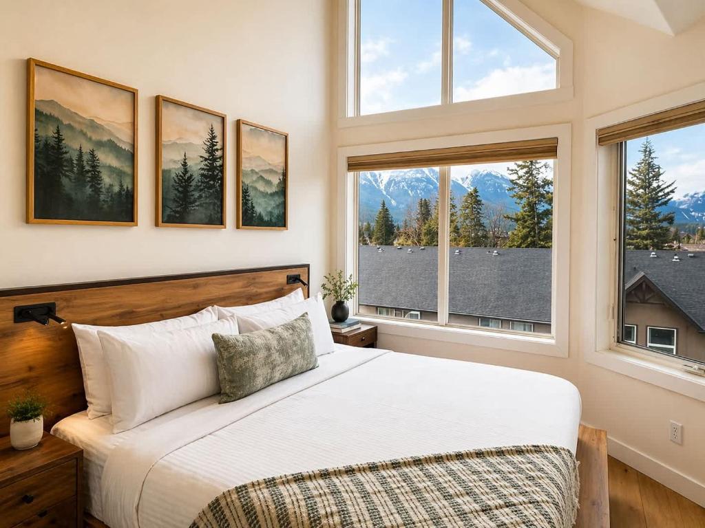 a bedroom with a bed in a room with windows at Alpine Hideaway at Alpine Village in Canmore